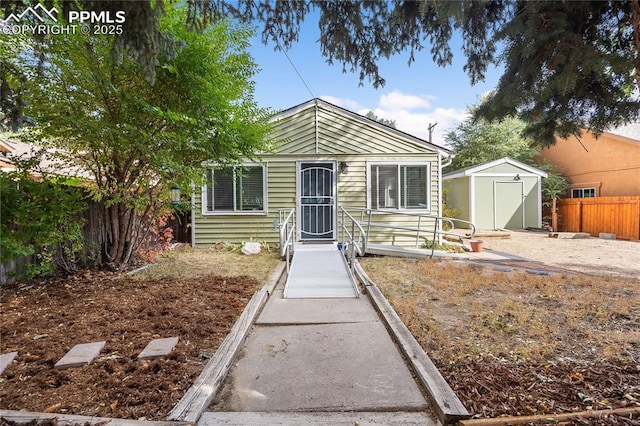 bungalow-style house featuring an outbuilding, a shed, and a fenced backyard