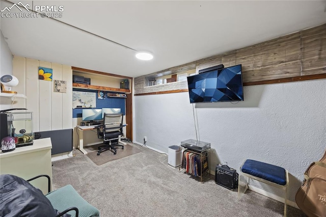 home office featuring carpet floors and a textured wall