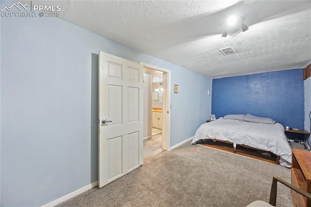 carpeted bedroom with visible vents, a textured wall, a textured ceiling, and baseboards