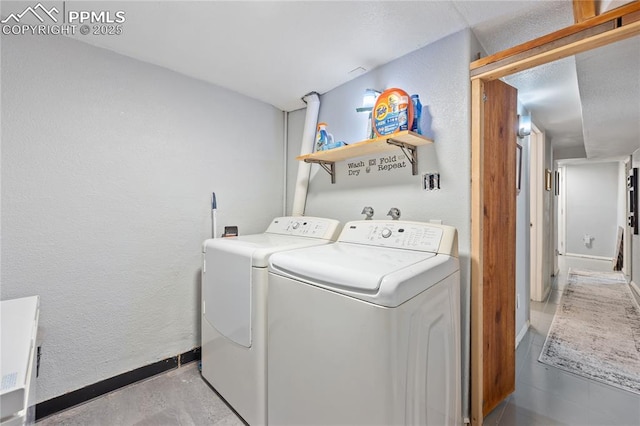 laundry area with a textured wall, laundry area, independent washer and dryer, and baseboards