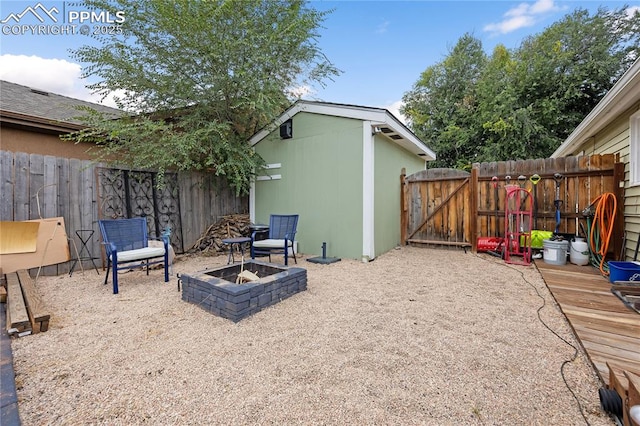 view of patio with an outdoor fire pit, fence, and a gate