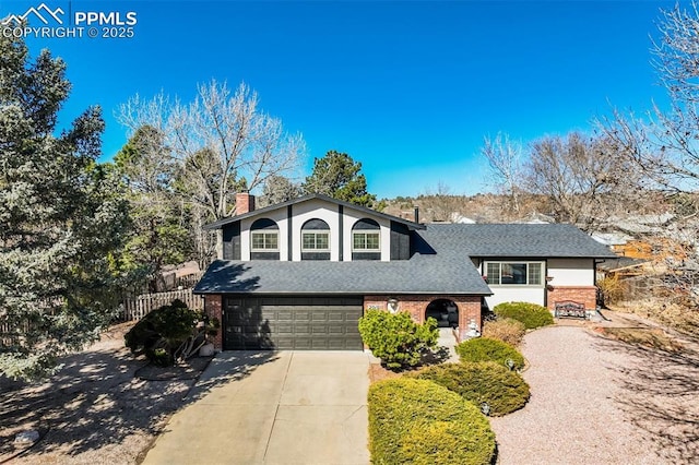 tri-level home featuring concrete driveway, brick siding, roof with shingles, and an attached garage