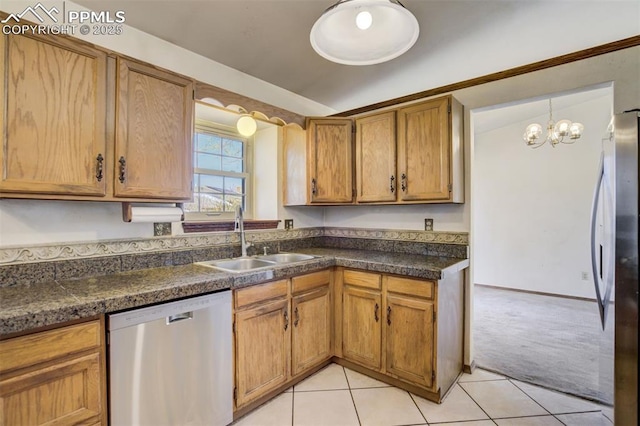 kitchen featuring dark countertops, brown cabinets, stainless steel appliances, and a sink