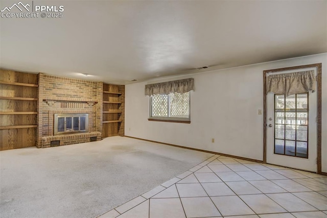 unfurnished living room with built in shelves, a fireplace, light tile patterned floors, light colored carpet, and baseboards