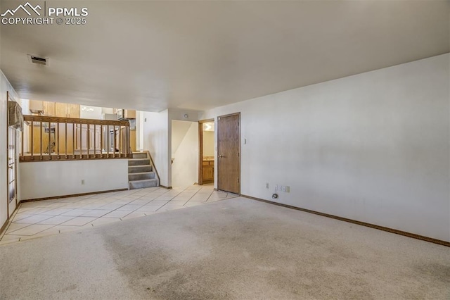 unfurnished living room featuring tile patterned flooring, visible vents, baseboards, stairway, and carpet