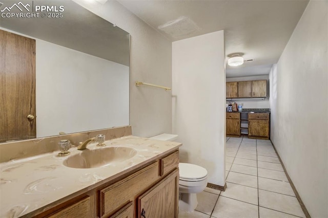 bathroom with baseboards, vanity, toilet, and tile patterned floors