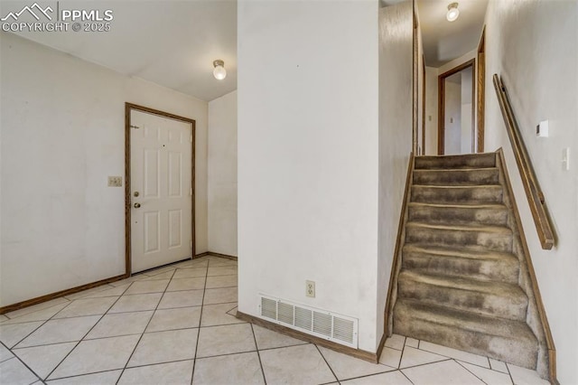 staircase featuring tile patterned flooring, visible vents, and baseboards