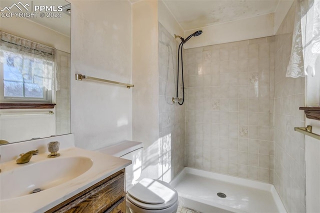 full bathroom featuring vanity, a tile shower, and toilet