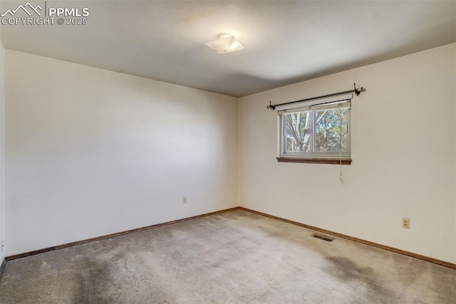 unfurnished room featuring baseboards, visible vents, and carpet flooring