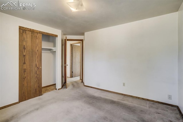 unfurnished bedroom featuring carpet, a closet, and baseboards