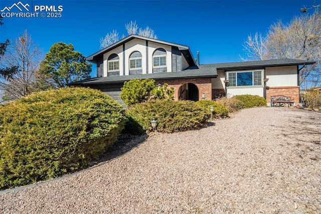 view of front of property featuring brick siding and stucco siding