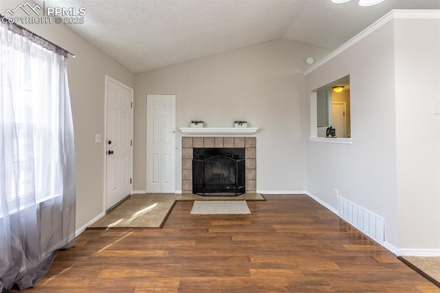 unfurnished living room featuring lofted ceiling, wood finished floors, visible vents, and a healthy amount of sunlight