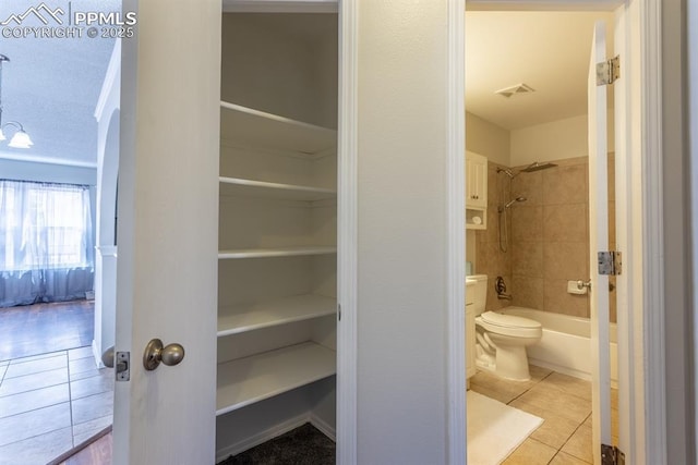 bathroom featuring  shower combination, visible vents, toilet, and tile patterned floors