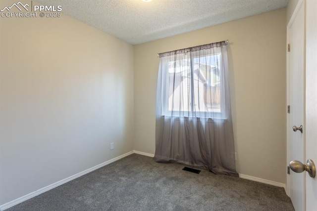 carpeted empty room with visible vents, a textured ceiling, and baseboards