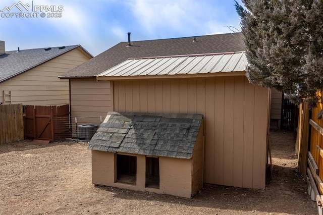 view of outdoor structure with cooling unit and a fenced backyard