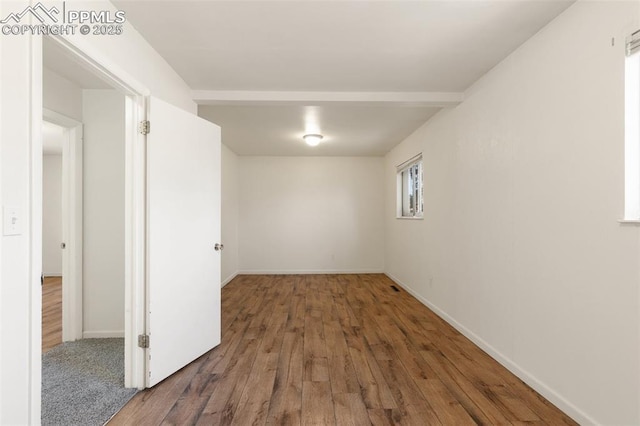 empty room with baseboards and wood finished floors