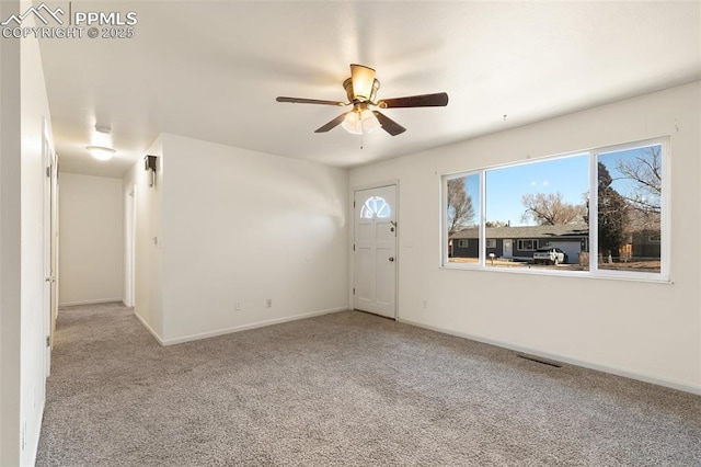 carpeted foyer with ceiling fan, visible vents, and baseboards