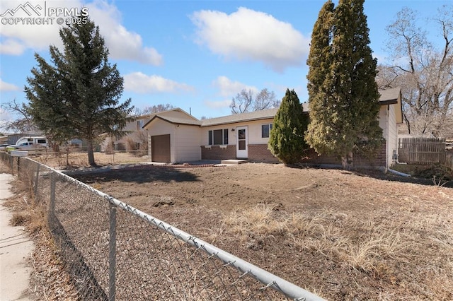 single story home with a garage, brick siding, and fence