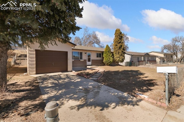 view of front of home with driveway, an attached garage, fence, and brick siding