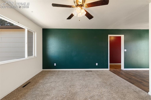 carpeted spare room with ceiling fan, a healthy amount of sunlight, visible vents, and baseboards