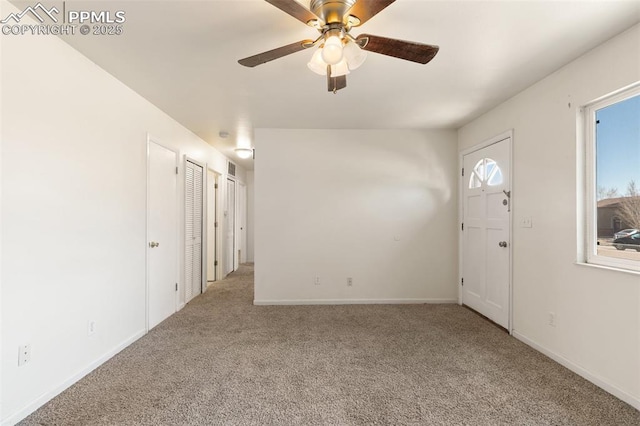 empty room with ceiling fan, baseboards, and carpet flooring