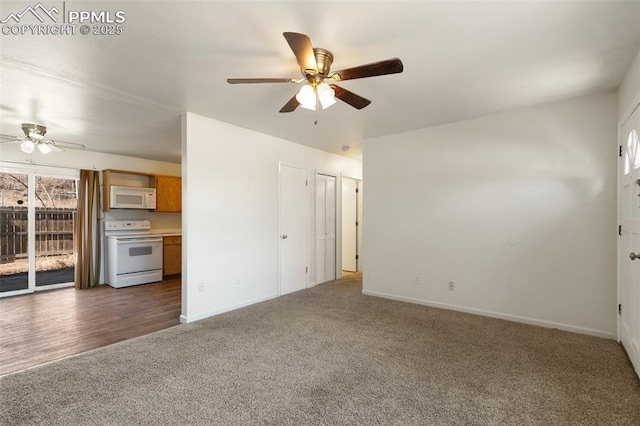 unfurnished living room with ceiling fan, dark carpet, and baseboards