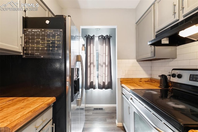 4054 Charleston Dr, Colorado Springs, CO 80916 - kitchen featuring tasteful backsplash, visible vents, butcher block counters, appliances with stainless steel finishes, and under cabinet range hood