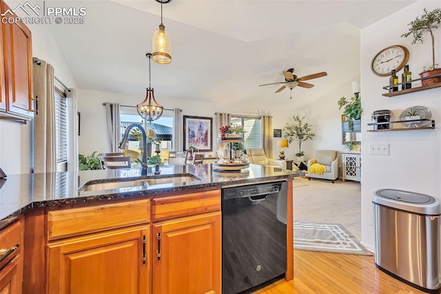 kitchen featuring a sink, dark stone countertops, black dishwasher, lofted ceiling, and hanging light fixtures