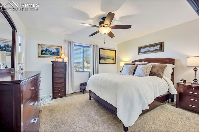 bedroom featuring light carpet, baseboards, and ceiling fan