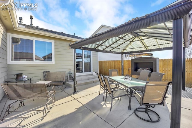 view of patio with outdoor dining space, a gazebo, and fence