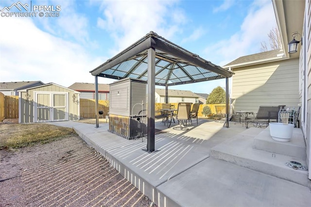 view of patio featuring outdoor dining area, fence, and a shed