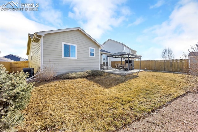 back of house featuring central AC unit, a fenced backyard, a gazebo, a patio area, and a lawn