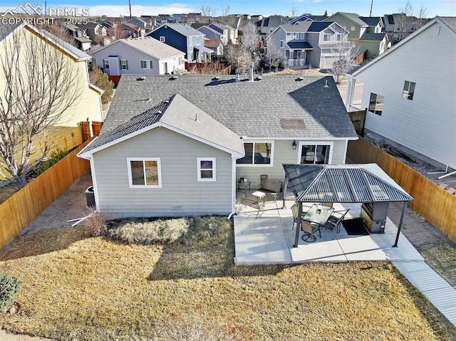 back of house featuring a patio, a fenced backyard, a residential view, and a shingled roof