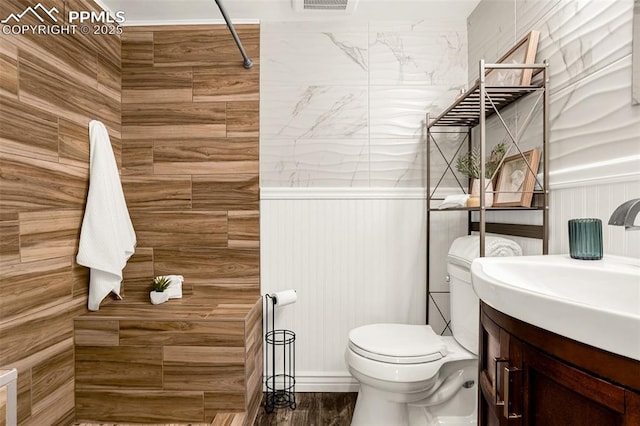 bathroom featuring vanity, toilet, and walk in shower