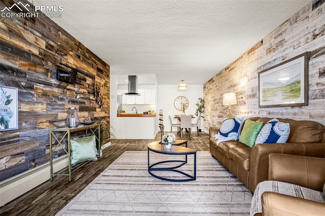 living area featuring a textured ceiling, wood walls, and wood finished floors