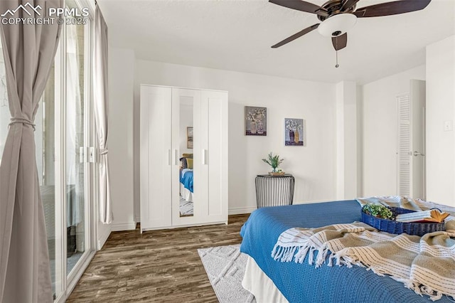 bedroom with dark wood-type flooring, ceiling fan, and baseboards