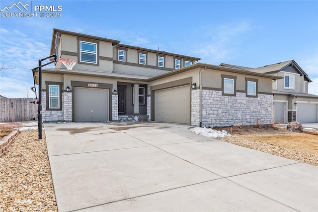 view of front of home featuring stone siding, fence, driveway, and stucco siding