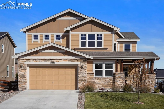 craftsman house featuring a front lawn, driveway, stone siding, board and batten siding, and a garage