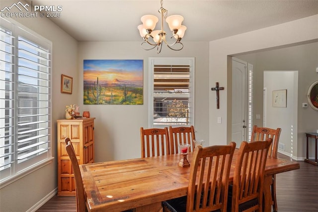 dining room with a notable chandelier, baseboards, and dark wood-style flooring