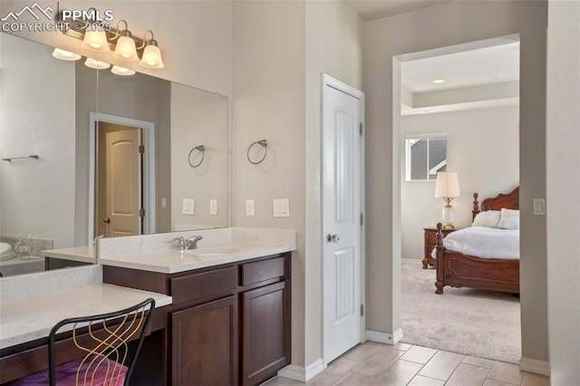 full bath with vanity, baseboards, and connected bathroom