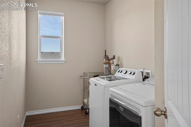 clothes washing area with baseboards, wood finished floors, washing machine and dryer, and laundry area