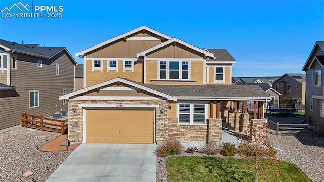 craftsman inspired home with board and batten siding, concrete driveway, a garage, and fence