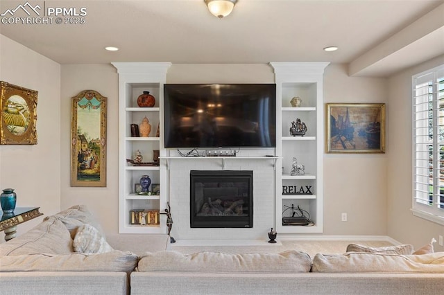 living area featuring built in features, recessed lighting, and a fireplace