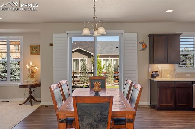 dining area with plenty of natural light, an inviting chandelier, and baseboards