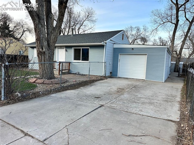 view of front facade featuring a garage, driveway, roof with shingles, and fence