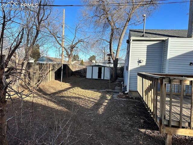 view of yard with an outbuilding, a fenced backyard, and a shed