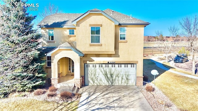 view of front of home featuring a garage, concrete driveway, roof with shingles, and stucco siding