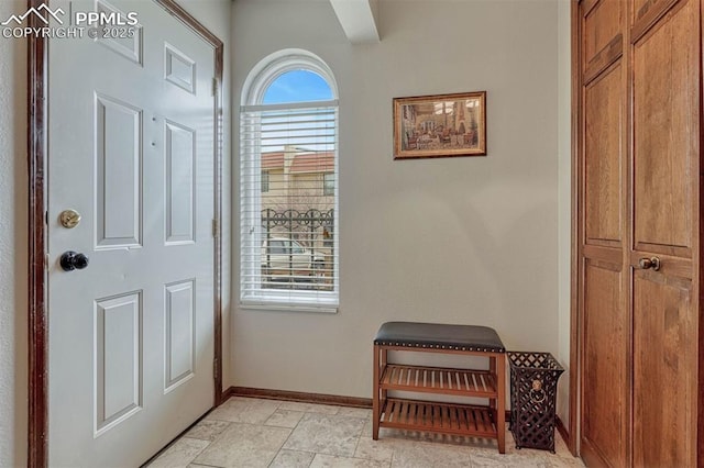 foyer entrance featuring stone finish flooring and baseboards