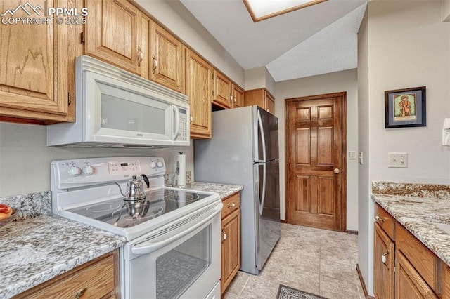 kitchen with white appliances, baseboards, and light stone countertops