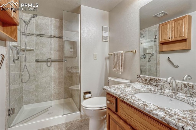 bathroom with a stall shower, visible vents, toilet, tile patterned flooring, and vanity